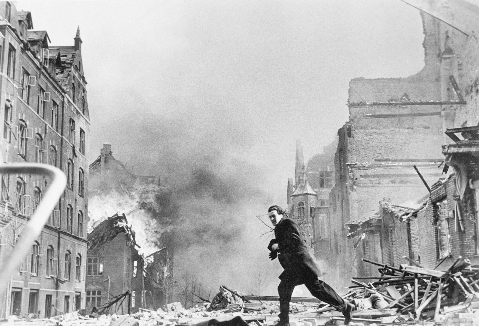 a man walking through a destroyed city street